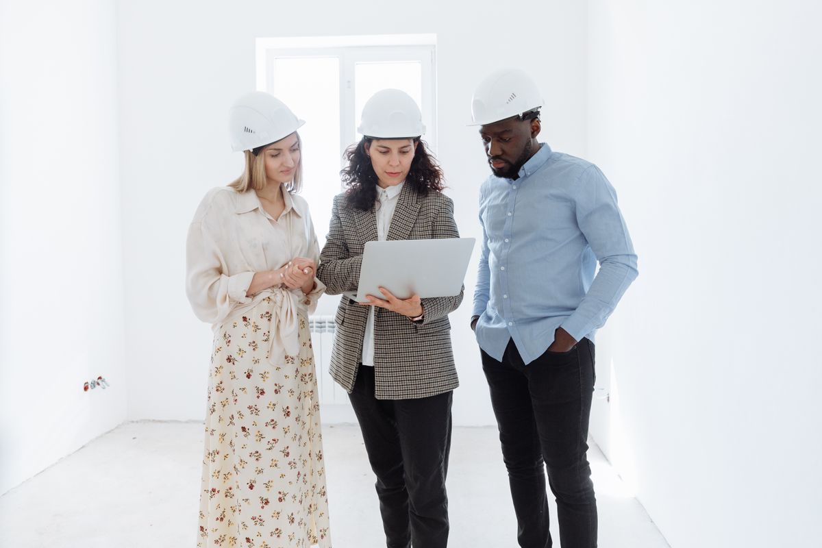 Construction professionals reviewing plans on a laptop