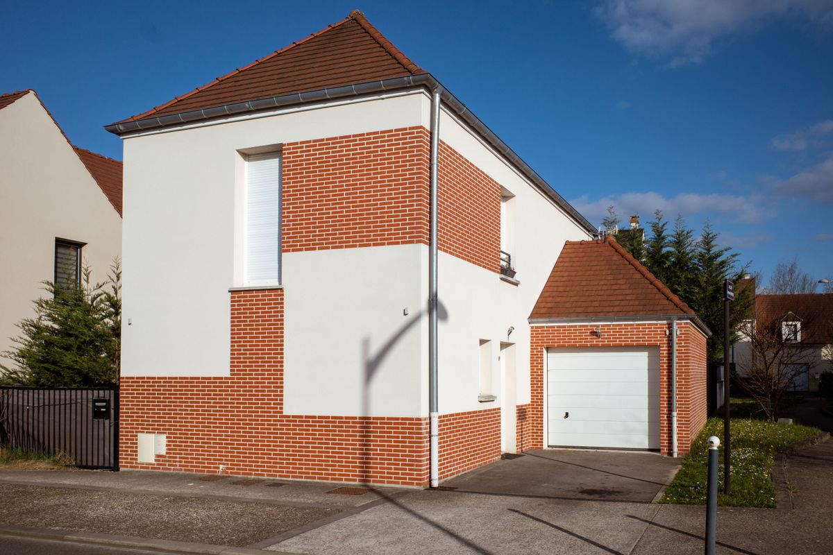 Contemporary home with red brick and light-coloured facade