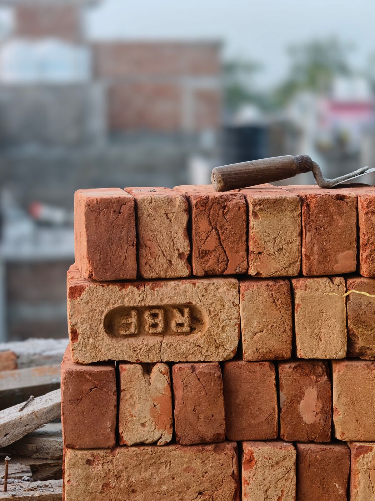 Stacked bricks and a trowel at a construction site