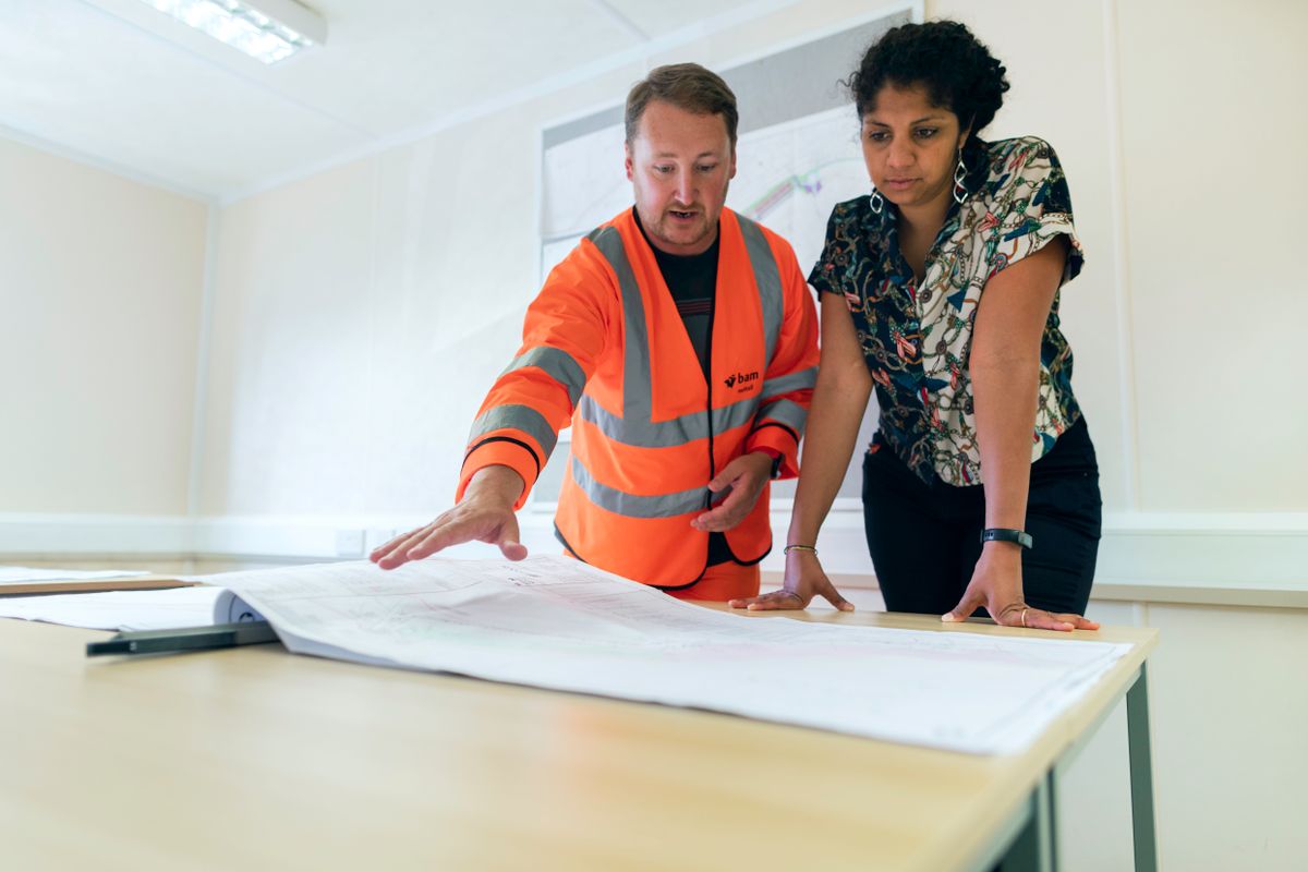 Engineers discussing project drawings in an office