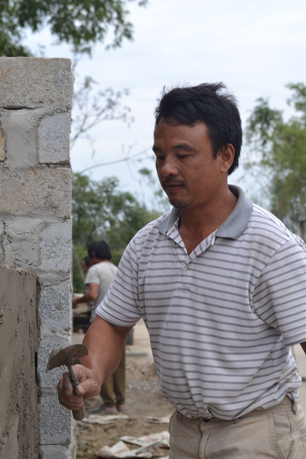 Mason applying mortar while building a wall