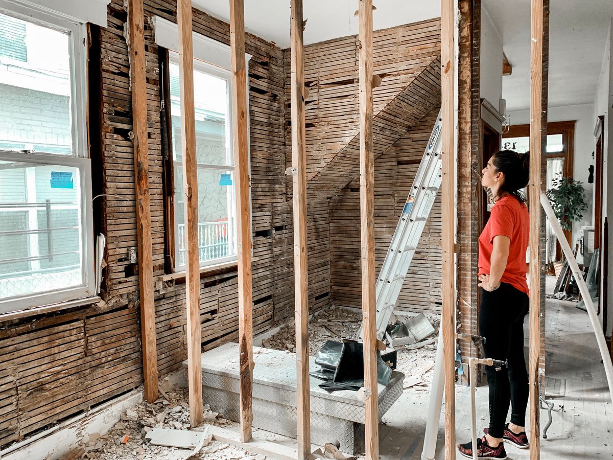 Person inspecting an unfinished room during refurbishment